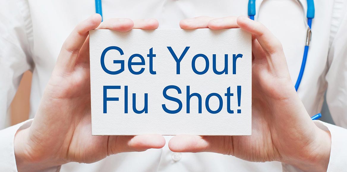 hands holding a sign that says get your flu shot!
